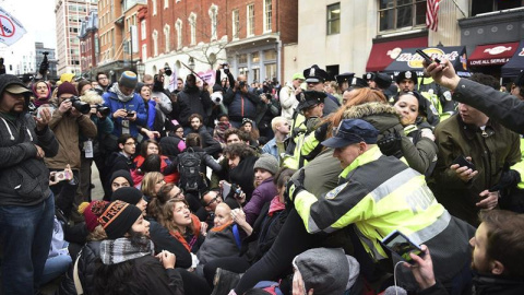 La policía ayuda a varias personas que trataban de asisitir al desfile de investidura y que han sido bloqueados por los manifestantes ubicados en la avenida Pennsylvania. - EFE