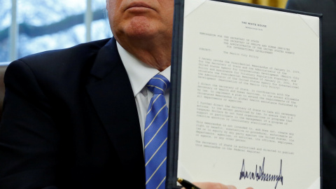 El presidente de EEUU, Donald Trump, muestra el decreto recien firmado para la retirada de Estados Unidos del acuerdo transpacífico. REUTERS/Kevin Lamarque