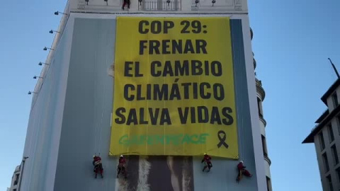 Greenpeace recuerda con una pancarta que "frenar el cambio climático salva vidas"