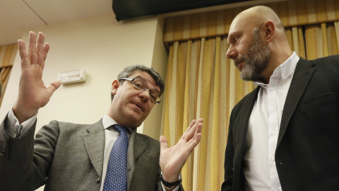 El ministro de Energía, Álvaro Nadal, conversa con el presidente de la Comisión de Energía y diputado de Unidos Podemos, antes de comparecer para explicar el comportamiento de los precios en los mercados de la energía. EFE/Fernando Alvarado