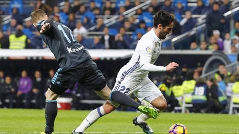 El centrocampista del Real Madrid, Francisco Alarcón "Isco" (d), se lleva el balón ante el jugador de la Real Sociedad, David Zurutuza, durante el encuentro que han disputado esta noche en el estadio Santiago Bernabéu, en Madrid. EFE / J. P