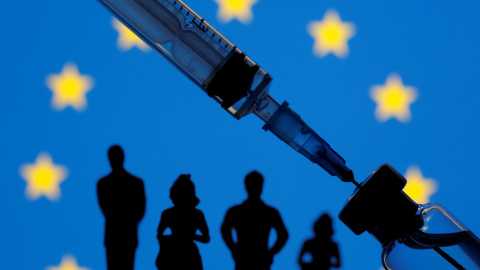 A vial, sryinge and small toy figures are seen in front of a displayed EU flag in this illustration taken January 11, 2021. REUTERS/Dado Ruvic/Illustration