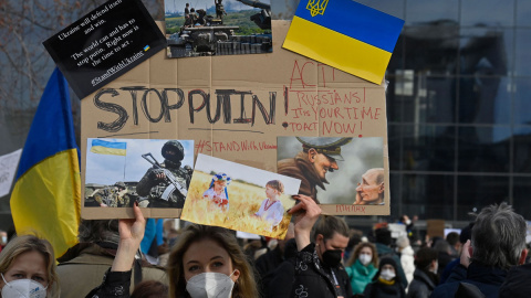  Una mujer sostiene un cartel que dice "Stop Putin" mientras la gente protesta contra la invasión rusa de Ucrania el 24 de febrero de 2022 cerca de la Cancillería en Berlín. John MACDOUGALL / AFP