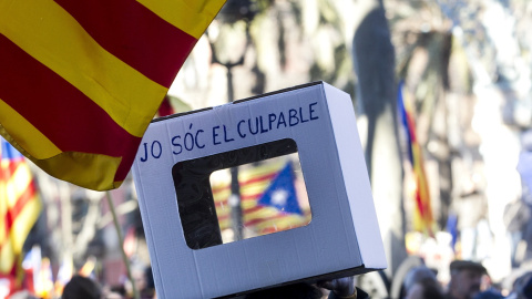 Una persona lleva una urna reivindicativa en apoyo al expresidente Artur Mas, la exvicepresidenta Joana Ortega, y la exconsellera Irene Rigau, durante la concentración de apoyo en su recorrido a pie desde el Palau de la Generalitat hasta el