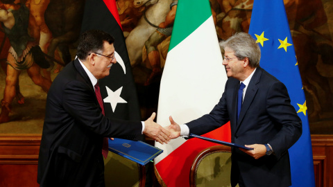 El primer ministro italiano Paolo Gentiloni (D) y su homólogo libio Fayez al-Sarraj se dan la mano después de firmar un acuerdo bilateral durante una reunión en Palacio de Chigi en Roma, Italia, el 2 de febrero de 2017.- REUTERS / Tony Gent