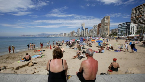 Una pareja de turistas toma el sol en las playas de Benidorm. EFE