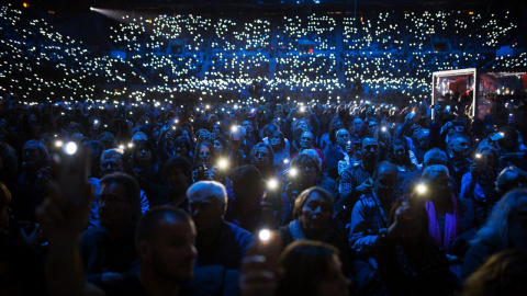 Assistents al concert en favor de l'acollida als refugiats il·luminen amb els seus mòbils