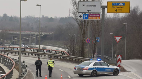 Un coche de policía bloquea uno de los accesos al aeropuerto de la ciudad alemana. | FABIAN BIMMER (EFE)