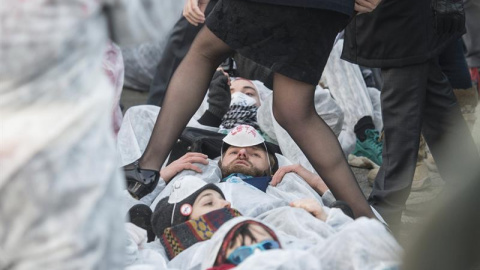 Una mujer pasa sobre el bloqueo de varios manifestantes al acceso al Parlamento Europeo, en Estrasburgo (Francia) mientras protestan contra el tratado de libre comercio e inversión de la Unión Europea con Canadá (CETA). EFE