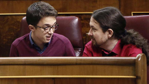 El líder de Podemos, Pablo Iglesias (d), conversa con el portavoz parlamentario de esta formación, Íñigo Errejón, en el hemiciclo del Congreso. | FERNANDO ALVARADO (EFE)