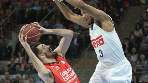 El ala pivot del Valencia Basket, Pierre Oriola (i), intenta encestar ante la defensa del pivot estadounidense del Real Madrid, Anthony Randolph, durante el encuentro correspondiente a la final de Copa del Rey, que disputan esta tarde en el