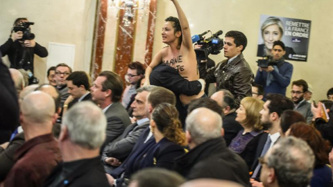 Una activista del grupo feminista Femen interrumpe la rueda de prensa de la líder del partido de extrema derecha Frente Nacional y candidata presidencial, Marine Le Pen (no en la imagen), durante una rueda de prensa sobre las políticas de e