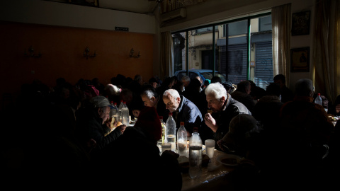 Varias personas tomando sopa de pollo en un comedor benéfico de la Iglesia Ortodoxa griega en Atenas. REUTERS/Alkis Konstantinidis