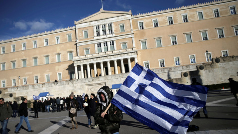 Un agricultor, con la bandera nacional griega, en la ateniense Plaza de Syntagma, donde está el Parlamento, tras una manifestación reclamando la bajada de impuestos.. REUTERS/Alkis Konstantinidis