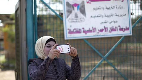 Una mujer hace una foto en el colegio de la comunidad de Jan al Ahmar. EFE/Atef Safadi