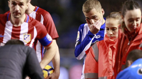 El centrocampista del Deportivo de la Coruña, Alejandro Bergantiños (3d), preocupado mientras los servicios médicos atienden al delantero del Atlético de Madrid, Fernando Torres