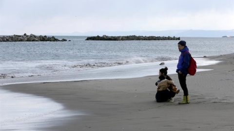 Una familia parada frente al mar de Fukushima en la conmemoración del sexto aniversario del terremoto de magnitud 9,9. EFE/ KIMIMA SA MAYAMA