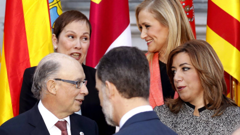 La presidenta de Andalucía, Susana Díaz, conversa con el ministro de Hacienda, Cristóbal Montoro, en presencia del rey Felipe VI, antes de posar para la foto de familia de la Conferencia de Presidentes. Detras, la presidenta madrileña Crist