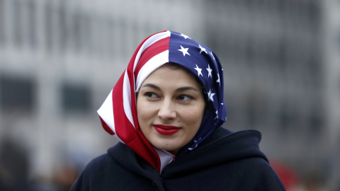 Una mujer musulmana con un velo con la bandera de Estados Unidos en la concentración contra Trump en Berlín / REUTERS