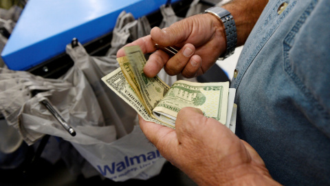 Un cliente cuenta su dinero en la caja de un supermercado de la cadena Walmart en Los Angeles. REUTERS/Kevork Djansezian