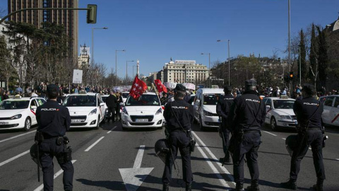 Agentes de la Policía Nacional vigilan durante la manifestación de los taxistas por el centro de Madrid. | SANTI DONAIRE (EFE)