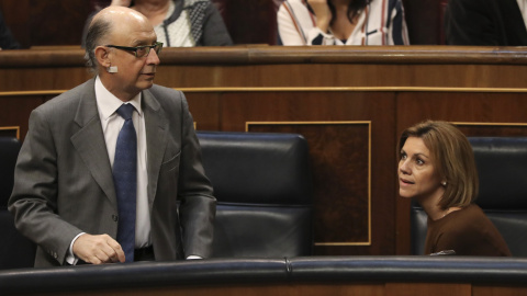 El ministro de Hacienda, Cristóbal Montoro, con la ministra de Defensa, María Dolores de Cospedal, durante el debate de convalidación del Real Decreto Ley de reforma de la estiba en el pleno del Congreso de los Diputados.EFE/Ballesteros