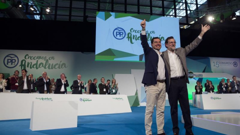 El presidente del Gobierno, Mariano Rajoy (d), y el líder del PP andaluz, Juanma Moreno (i), saludan tras finalizar la intervención del jefe del Ejecutivo, durante la clausura del 15 Congreso Autonómico del Partido Popular que se ha celebra