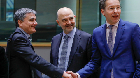 El ministro de finanzas griego Euclid Tsakalotos, junto al Comisario europeo de Economía y Finanzas, Pierre Moscovici junto al presidente del Eurogrupo, Jeroen Dijsselbloem en una reunión de ministros de finanzas en Bruselas.REUTERS/Yves He