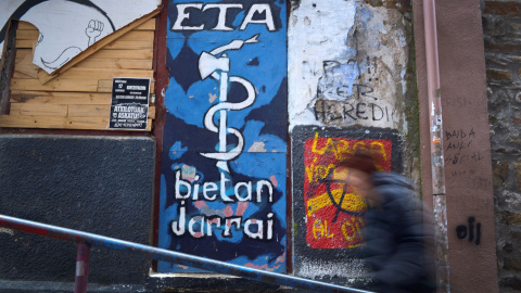 Una personas camina delante de una pintada de ETA en Bermeo, REUTERS/Vincent West