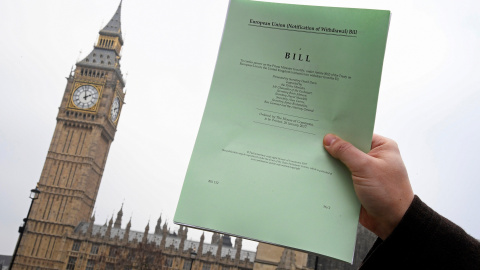 Un periodista posa frente al parlamento británico con una copia del documento del Brexit .REUTERS/Toby Melville