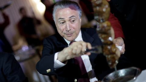 El presidente de Brasil Michel Temer comiendo carne con importantes empresarios