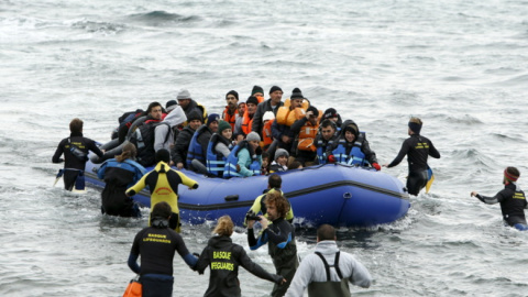 Un grupo de voluntarios acude a rescatar a los refugiados al llegar a la isla de Lesbos. REUTERS