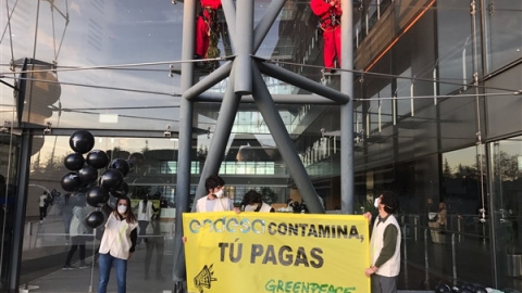 En la sede de Endesa en Madrid los escaladores encaramados en el edificio con la pancarta "Endesa contamina, tú pagas". / GREENPEACE