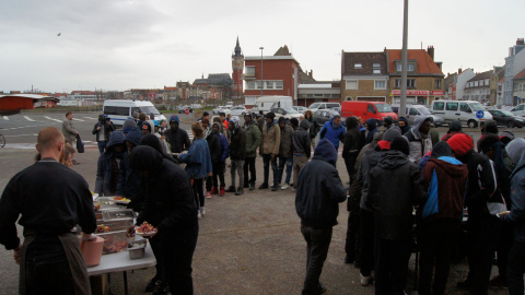 Varios refugiados esperan en la cola para recibir comida / ENRIC BONET