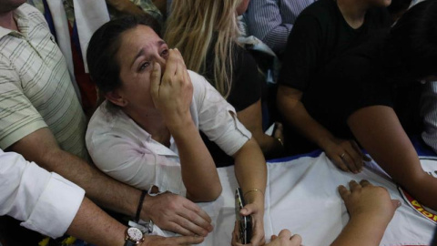 Amigos y familiares de Rodrigo Quintana, quien murió esta madrugada tras las protestas y disturbios de anoche en Asunción, se lamentan sobre el feretro.- EFE/Andrés Cristaldo Benítez