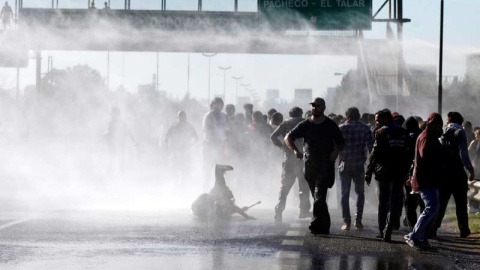 Varios manifestantes son reprimidos con mangueras de agua durante la jornada de huelga general en Argentina. | REUTERS