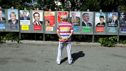 Un hombre mira los carteles de la campaña de los hasta 11 candidatos que se presentan a las elecciones presidenciales francesas. REUTERS/Eric Gaillard