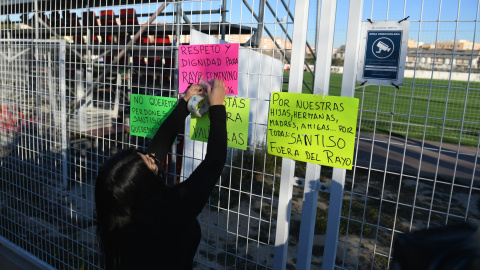  Una mujer coloca carteles para mostrar rechazo al nuevo entrenador del Rayo Vallecano, durante un partido de fútbol.- Fernando Sánchez / Europa Press