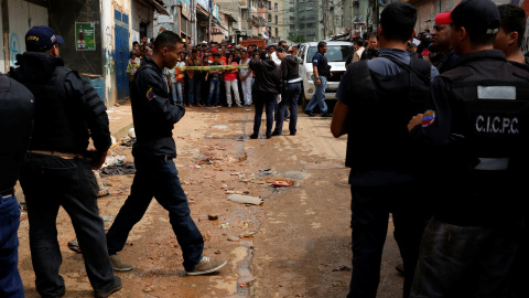 Policías e investigadores buscan evidencia frente a una panadería saqueada en Caracas. REUTERS / Carlos Garcia Rawlins