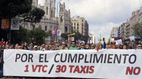 Decenas de taxistas portan una pancarta durante la manifestación hoy en la madrileña calle Raimundo Fernández Villaverde. EFE/Víctor Lerena