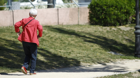 Una mujer mayor camina por un parque de Madrid. E.P.