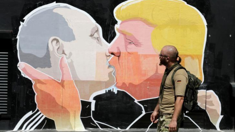 Un hombre pasa por delante de un graffiti que representa a Donald Trump (R) presidente de Estados Unidos y Vladimir Putin, presidente de Rusia, en Vilnius, Lituania. REUTERS / Ints Kalnins