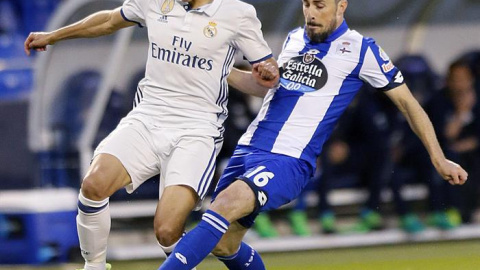 El defensa portugués del Deportivo Luís Carlos Correia "Luisinho" (d) y el centrocampisto del Real Madrid Lucas Vázquez, durante el partido de la trigésimo cuarta jornada de liga en Primera División que se disputa esta noche en el estadio d