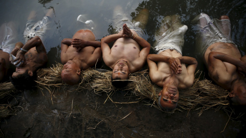 Unos devotos se sumergen en las aguas del río Hanumante para rezar durante la festividad de Swasthani Brata Katha (durante un mes, los creyentes recitan unos capítulos hindúes para honrrar a este dios). Bhaktapur, Nepal. REUTERS/Navesh Chit