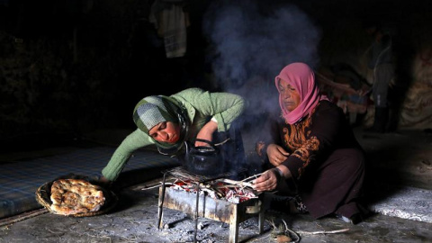 Dos mujeres de la familia Hamadeh cocinan en la cueva que les sirve de vivienda, en las afueras del pueblo de Mufagra, cerca de la ciudad cisjordana de Hebrón.  EFE/Abed Al Hashlamoun