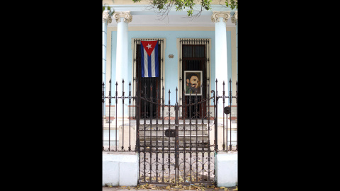 Una bandera cubana y un retrato de Castro cuelgan de una puerta en El Vedado. /Marian León y Lucía M. Quiroga