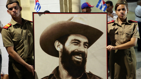 Dos personas portan un retrato de Fidel Castro, mientras llega la caravana con las cenizas del fallecido líder de la revolución cubana por la ciudad de Bayamo. EFE/Alejandro Ernesto