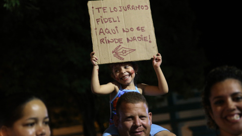 Una pancarta que reza "¡Te lo juramos Fidel! ¡Aquí no se rinde nadie!" es sujetada por un niño durante el recorrido de a caravana con las cenizas del fallecido líder de la revolución cubana, Fidel Castro, que transita por la ciudad de Bayam