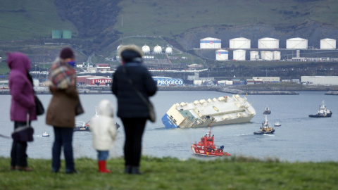 Varias personas observan el carguero "Modern Express", que se encontraba a la deriva en el Golfo de Vizcaya tras sufrir una fuerte escora, entrando remolcado al puerto de Bilbao. El mercante se encuentra desde las 5 de la tarde dentro del p