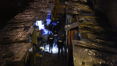 Policías evacúan un campamento de gitanos emigrantes, en las antiguas vías del tren a lo largo del bulevar Ney en el norte de París, 3 de febrero de 2016. Cientos de personas fueron evacuadas. AFP / DOMINIQUE FAGET